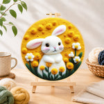 Finished sunny white bunny and yellow flowers needle felting displayed on a wooden easel