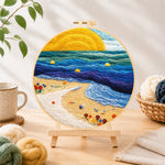 Finished sunset beach and blue rolling waves needle felting displayed on a wooden easel