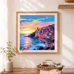 Finished sunset cliffside coastal village cross stitch artwork displayed as home decor