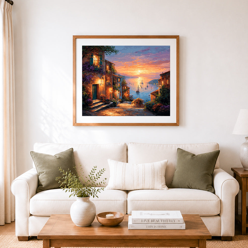 Finished sunset coastal village with glowing windows and sailboats cross stitch artwork displayed as home decor