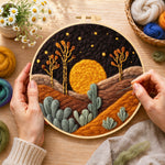 Creating the sunset in the desert wool painting by hand with a felting needle
