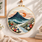 Sunset over mountain peaks embroidery hoop wall art displayed as warm and cozy handmade home decor