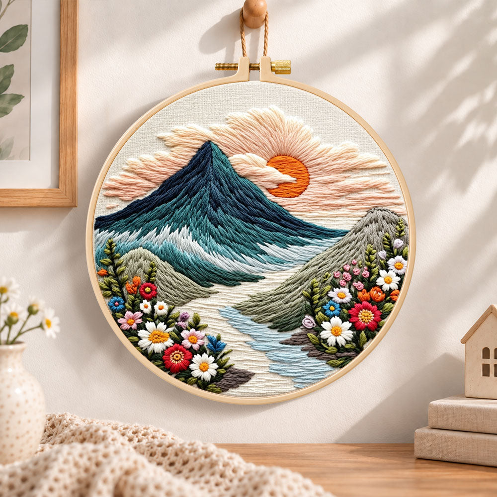 Sunset over mountain peaks embroidery hoop wall art displayed as warm and cozy handmade home decor