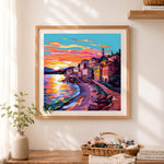 Finished sunset seaside coastal town cross stitch artwork displayed as home decor