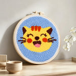 Super happy cat punch needle artwork displayed on a table