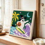 Surfing halloween ghost punch needle artwork displayed on a table