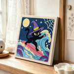 Surfing witch black cat punch needle artwork displayed on a table