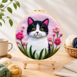 Finished sweet cat and vibrant pink flowers needle felting displayed on a wooden easel