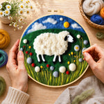 Creating the sweet sheep on a green rolling hill wool painting by hand with a felting needle