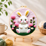 Finished sweet white bunny and pink flowers needle felting displayed on a wooden easel