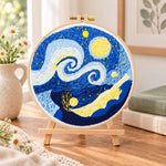 Swirling starry sky art embroidery kit finished hoop displayed on a wooden stand as cozy tabletop decor