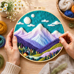 Creating the teal sky and purple mountains wool painting by hand with a felting needle