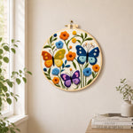 Three whimsical butterflies among flowers needle felt wall art displayed in a bright home interior