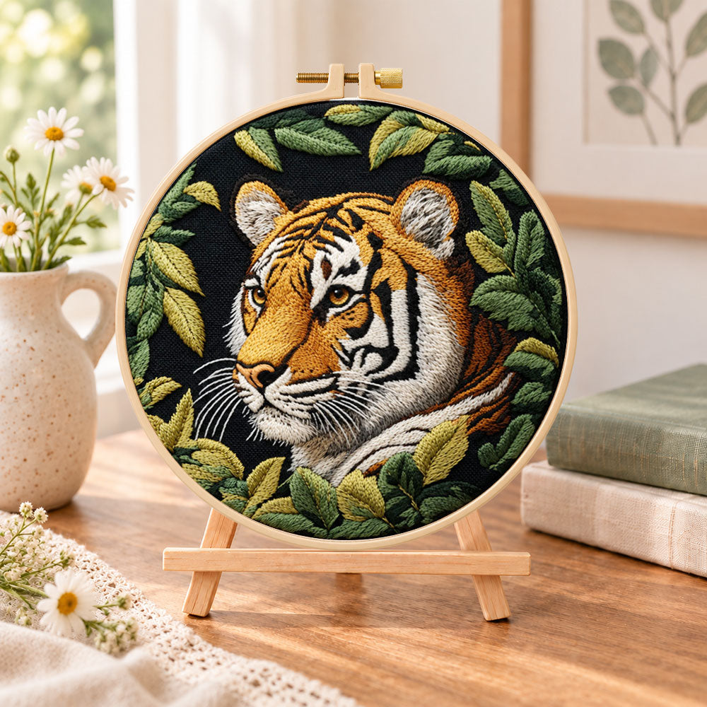 Tiger among green leaves embroidery kit finished hoop displayed on a wooden stand as cozy tabletop decor