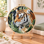 Tiger in jungle foliage embroidery kit finished hoop displayed on a wooden stand as cozy tabletop decor