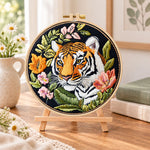 Tiger with wild blooms embroidery kit finished hoop displayed on a wooden stand as cozy tabletop decor