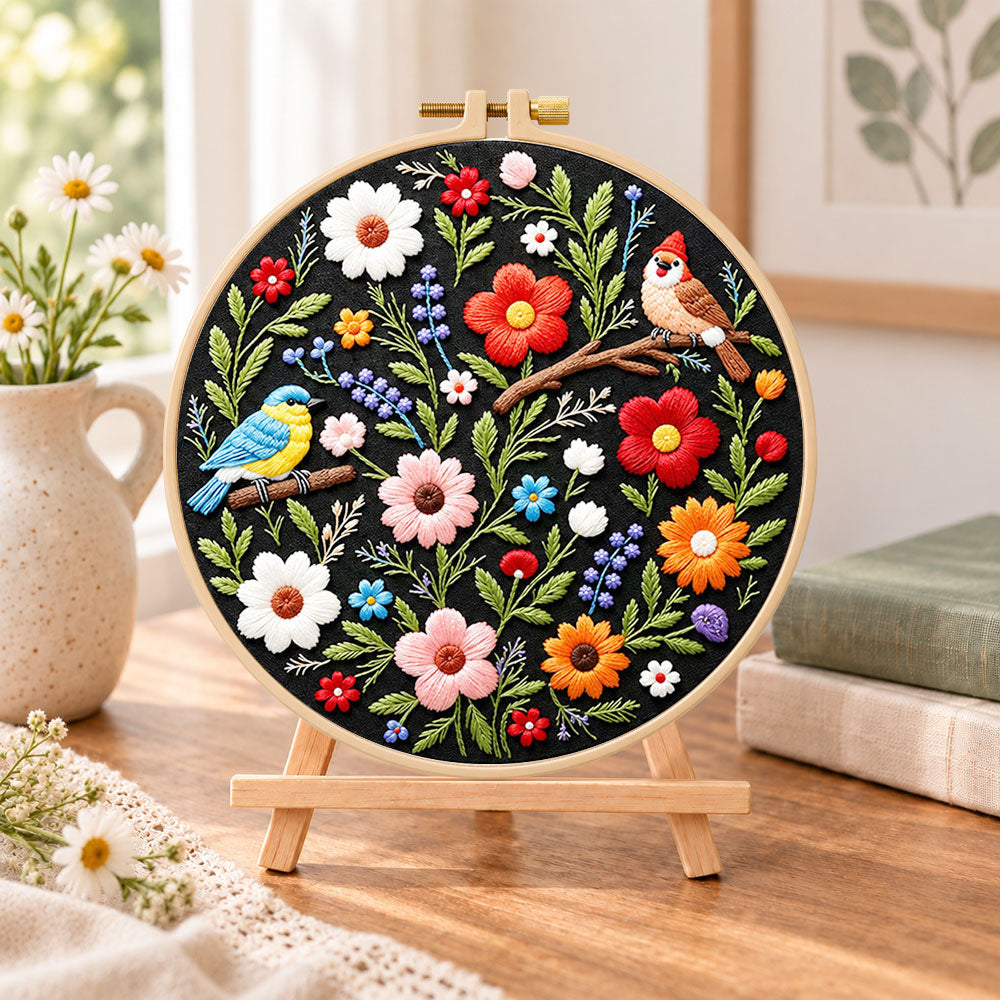 Titmouse and colorful wildflowers embroidery kit finished hoop displayed on a wooden stand as cozy tabletop decor
