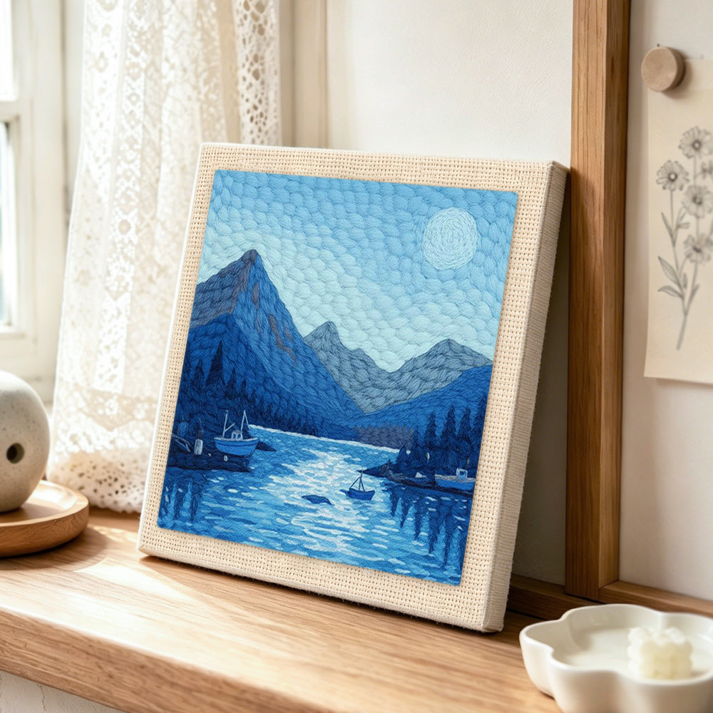 Tranquil blue fjord and boats punch needle artwork displayed on a table