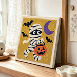 Trick or treat mummy punch needle artwork displayed on a table