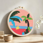 Tropical palm tree sunset punch needle artwork displayed on a table