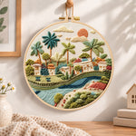 Tropical riverside hamlet embroidery hoop wall art displayed as warm and cozy handmade home decor