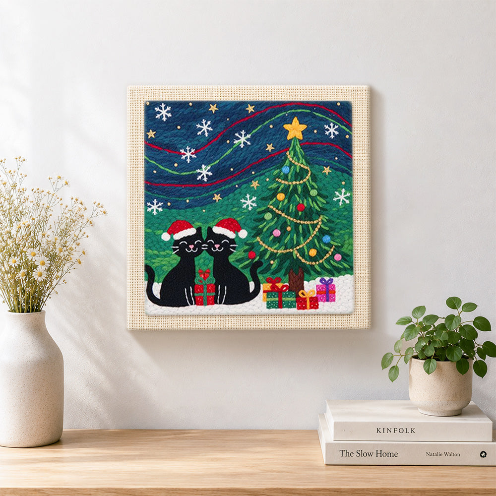 Finished two black cats under christmas tree artwork displayed on a wall