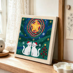 Two cats in santa hats punch needle artwork displayed on a table