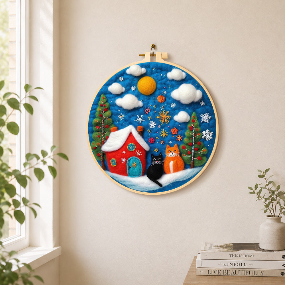 Two christmas cats with red house needle felt wall art displayed in a bright home interior
