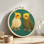 Two cute parrots punch needle artwork displayed on a table