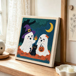 Two cute trick or treat ghosts punch needle artwork displayed on a table