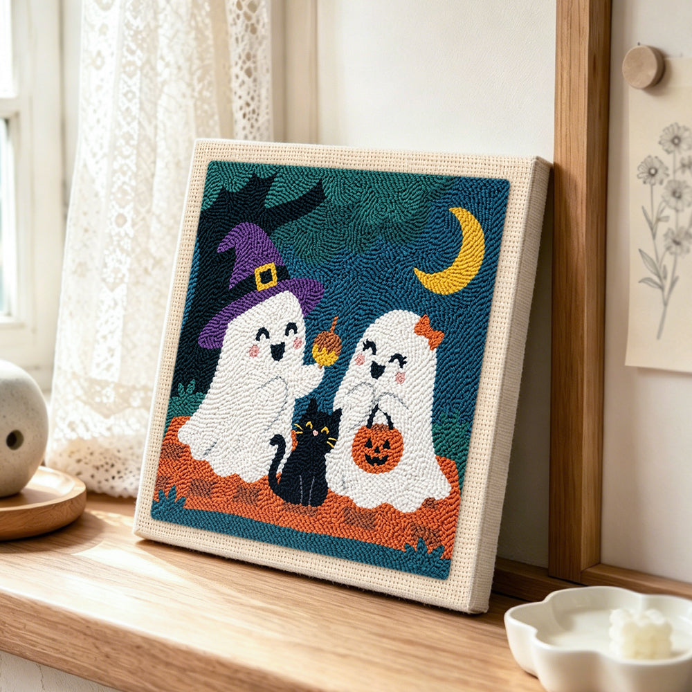 Two cute trick or treat ghosts punch needle artwork displayed on a table