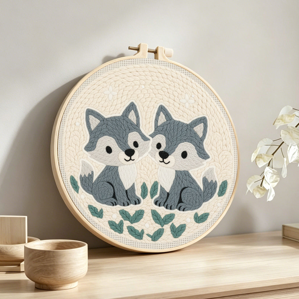 Two little gray foxes punch needle artwork displayed on a table
