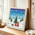 Two reindeers in snow punch needle artwork displayed on a table