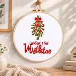 Under the mistletoe embroidery hoop wall art displayed as warm and cozy handmade home decor