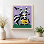 Finished vampire raccoon with pumpkin bucket artwork displayed on a wall