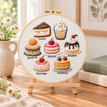 Variety of little cakes embroidery kit finished hoop displayed on a wooden stand as cozy tabletop decor