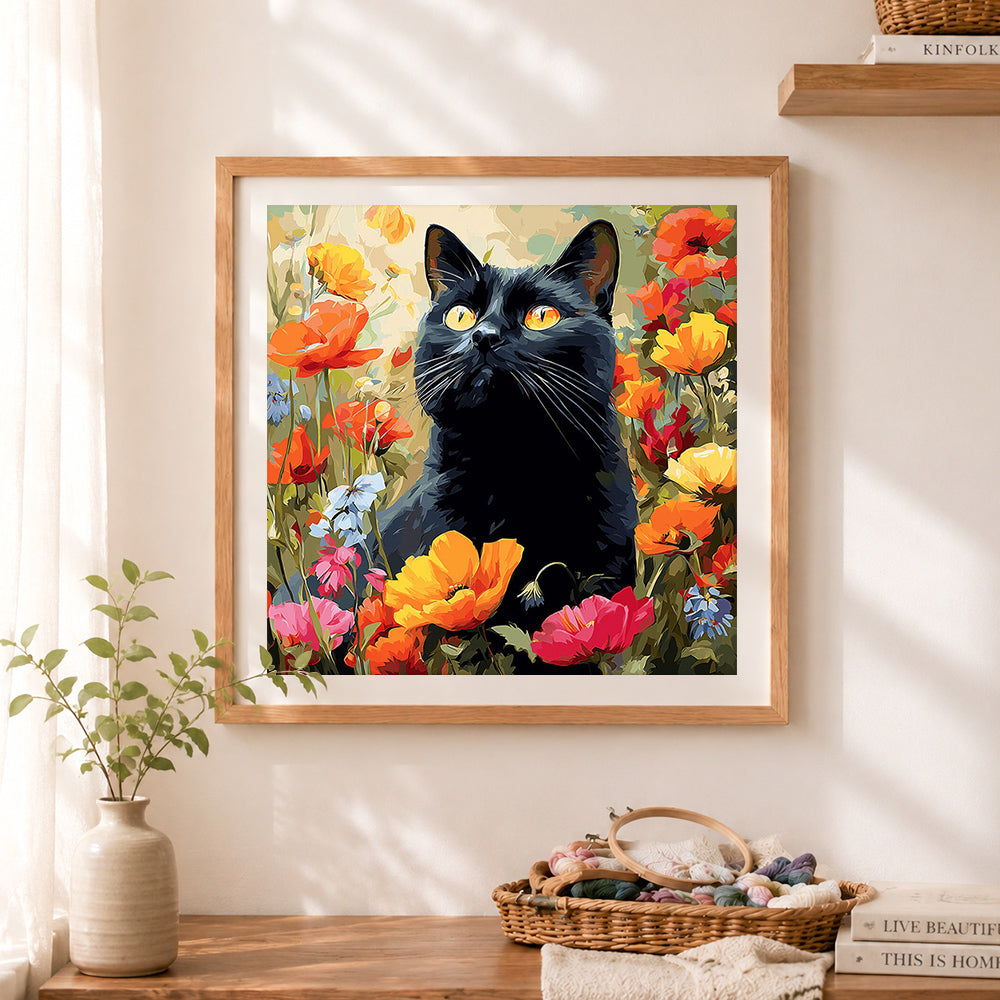 Finished vibrant black cat in floral garden cross stitch artwork displayed as home decor