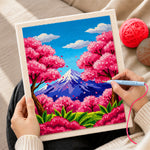 Creating handmade vibrant cherry blossom trees and snowy peak punch needle artwork
