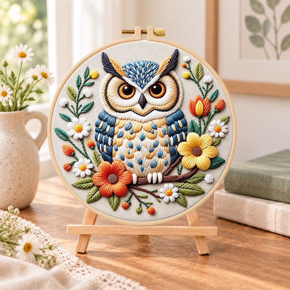 Vibrant floral owl embroidery kit finished hoop displayed on a wooden stand as cozy tabletop decor