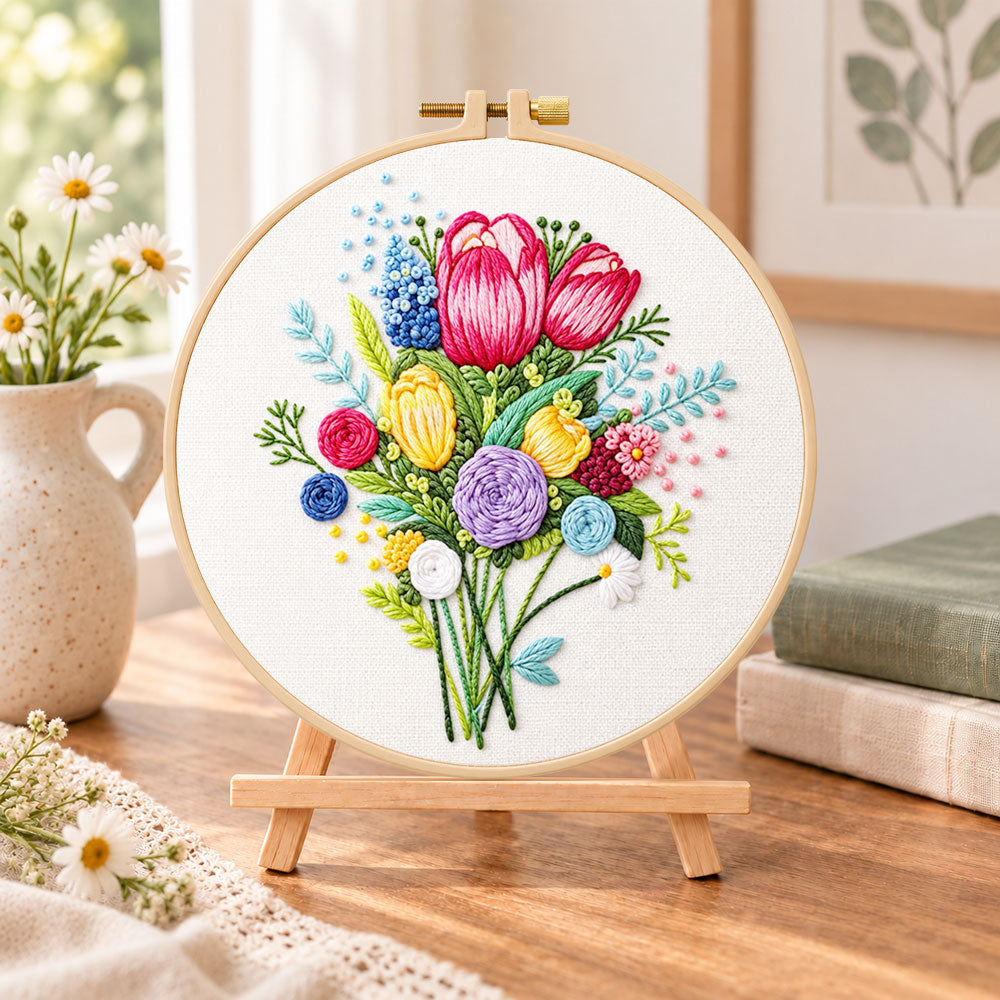 Vibrant flower bouquet embroidery kit finished hoop displayed on a wooden stand as cozy tabletop decor