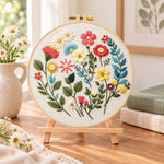 Vibrant garden sprigs embroidery kit finished hoop displayed on a wooden stand as cozy tabletop decor