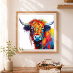 Finished vibrant highland cow with paint drips cross stitch artwork displayed as home decor