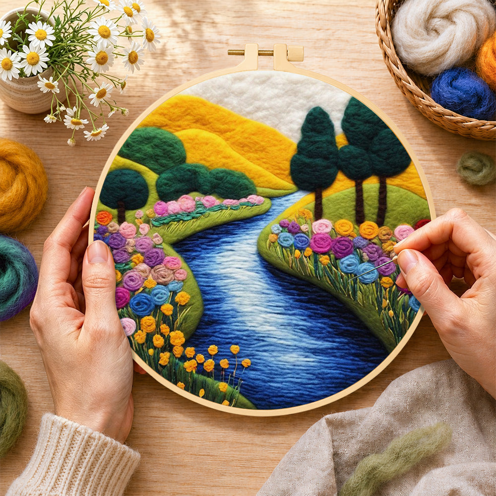 Creating the vibrant rolling hills, sunny river and rainbow flowers wool painting by hand with a felting needle