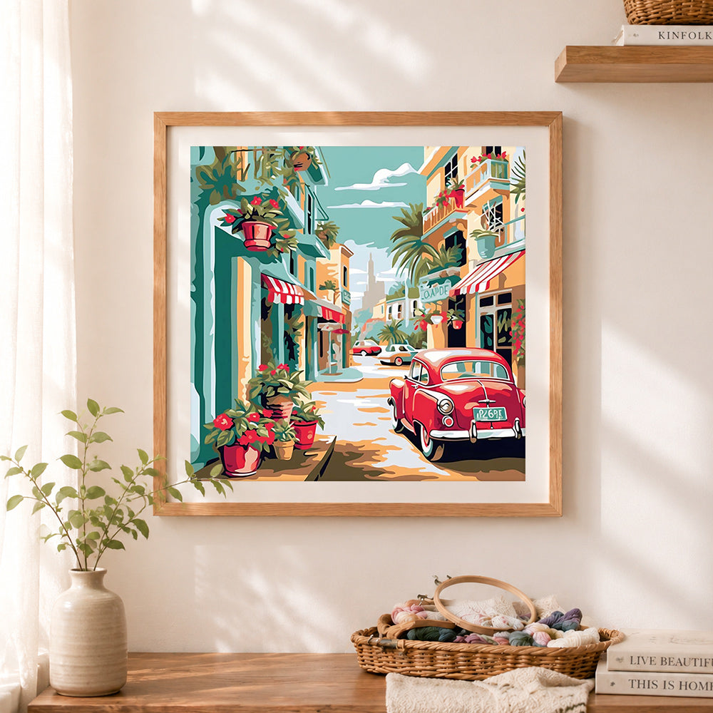 Finished vintage coastal street with classic car cross stitch artwork displayed as home decor