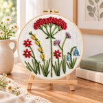 Vintage floral cluster embroidery kit finished hoop displayed on a wooden stand as cozy tabletop decor