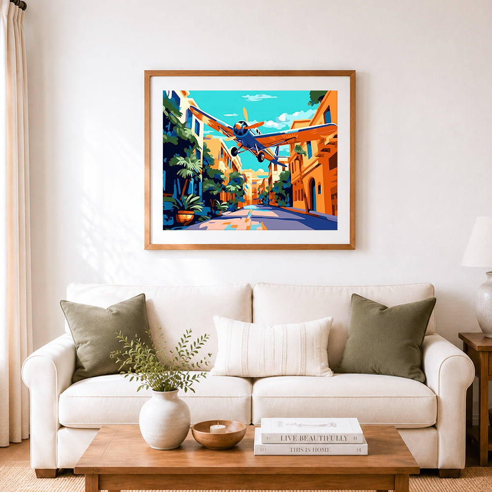 Finished vintage plane over mediterranean town cross stitch artwork displayed as home decor