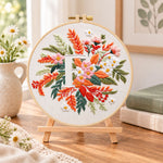 Warm autumn foliage and letter f embroidery kit finished hoop displayed on a wooden stand as cozy tabletop decor