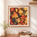 Finished warm golden and red autumn leaves cross stitch artwork displayed as home decor