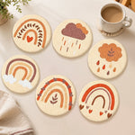 Warm-toned rainbow and cloud punch needle coasters used for home decoration