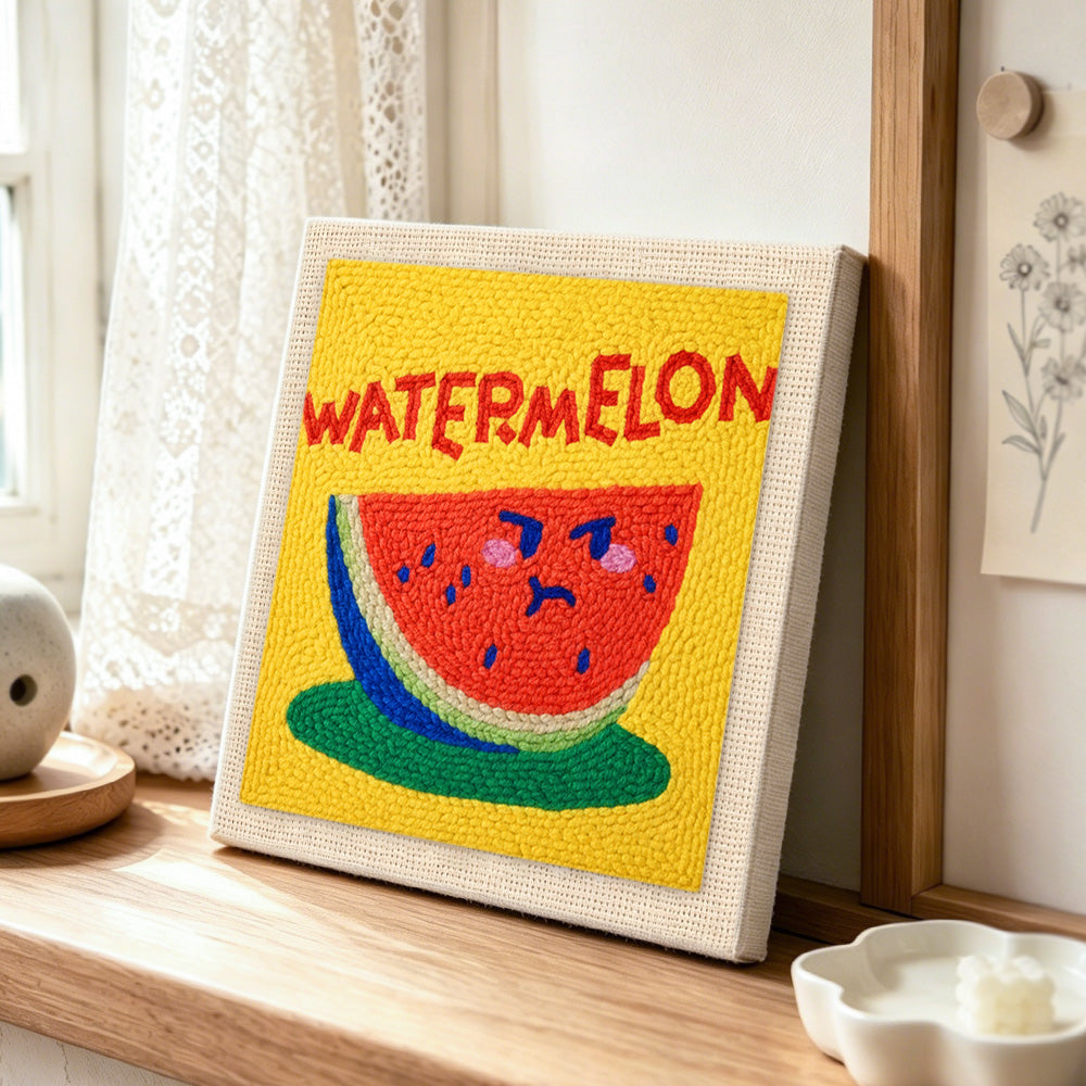watermelon with cute face punch needle artwork displayed on a table